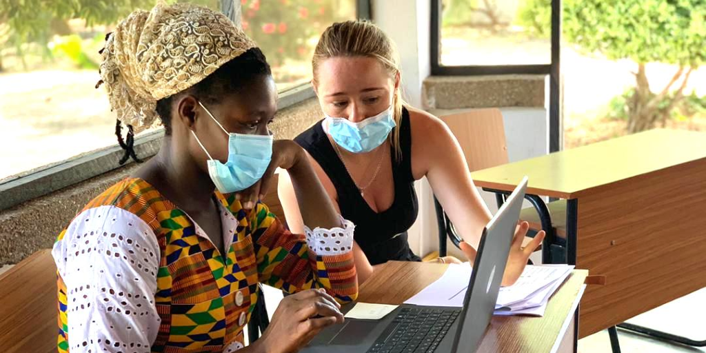 A GVI participant helps a lady with computer literacy during a women's empowerment program. 